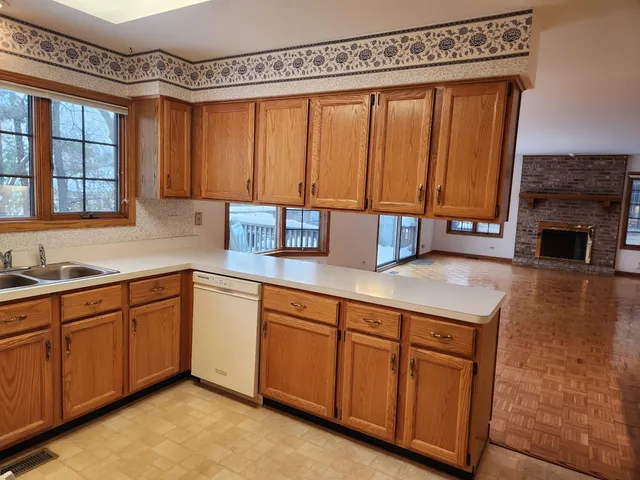 an empty room with windows and fireplace