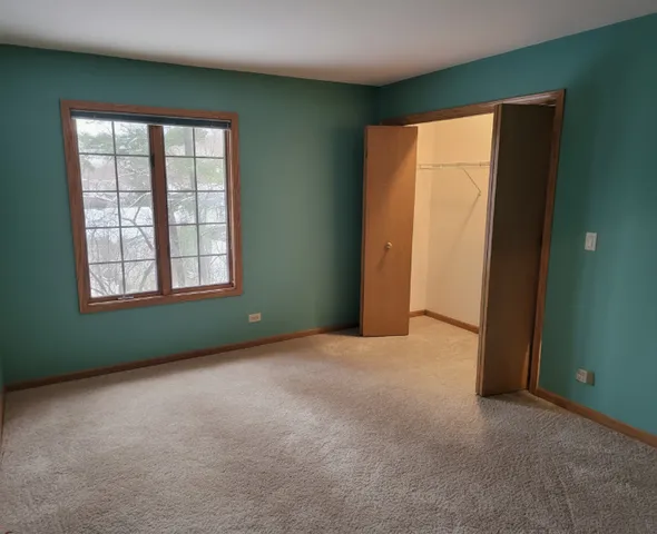 a view of an empty room with wooden floor and closet