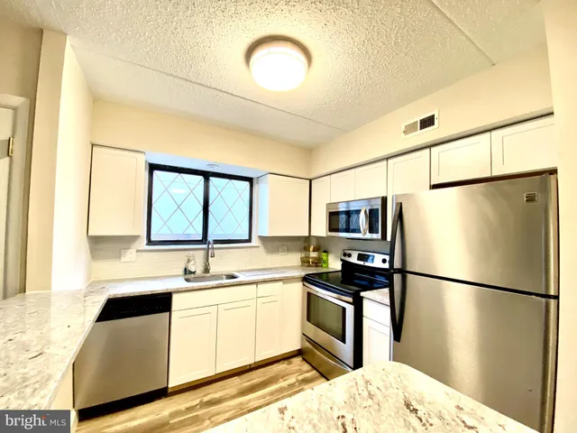 a kitchen with stainless steel appliances a refrigerator sink and cabinets