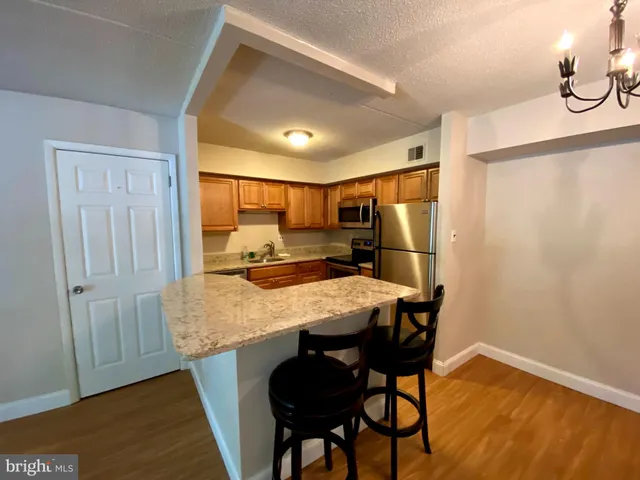 a kitchen with stainless steel appliances granite countertop a sink refrigerator and microwave