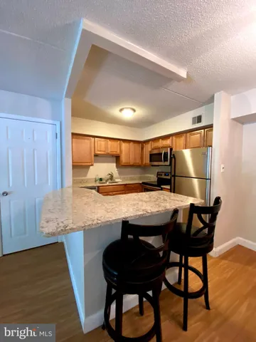 a kitchen with a table chairs and wooden floor
