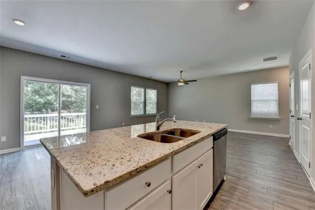 a kitchen with a granite countertop sink and natural light