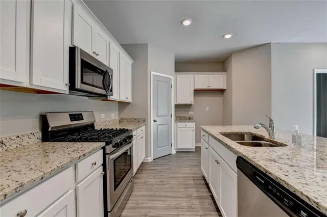 a kitchen with granite countertop a sink and steel appliances