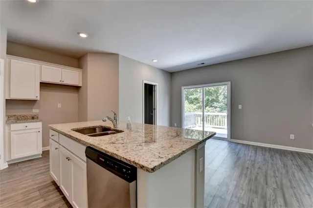a kitchen that has a sink a stove and wooden floor