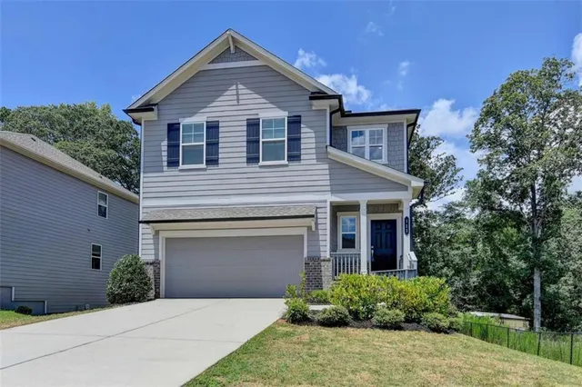 a front view of a house with yard and green space