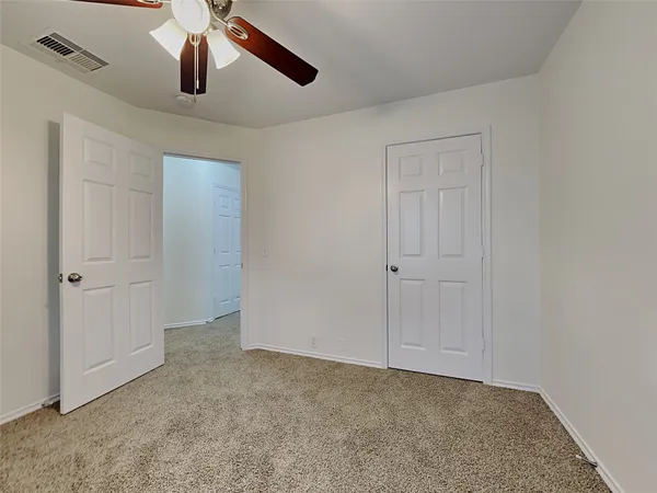 an empty room with a ceiling fan and fan
