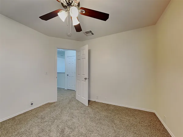 an empty room with chandelier fan