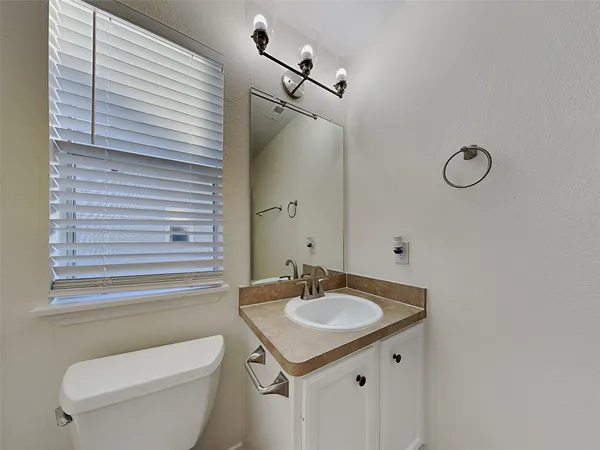 a bathroom with a toilet a sink and mirror