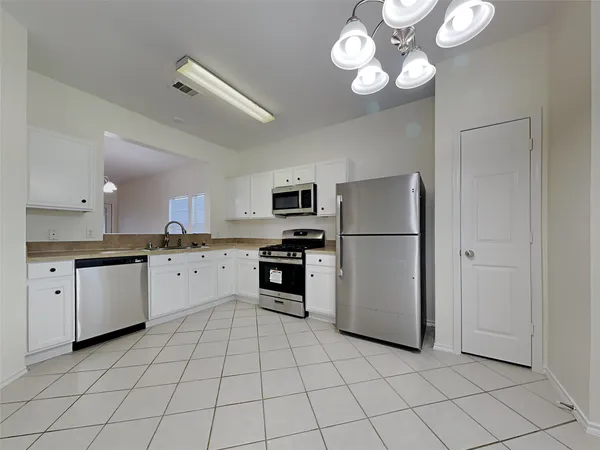 an empty room with chandelier and windows