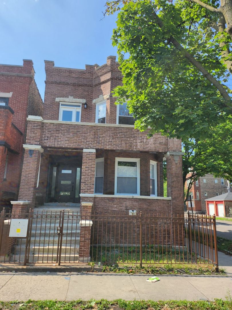 front view of a brick house with a yard