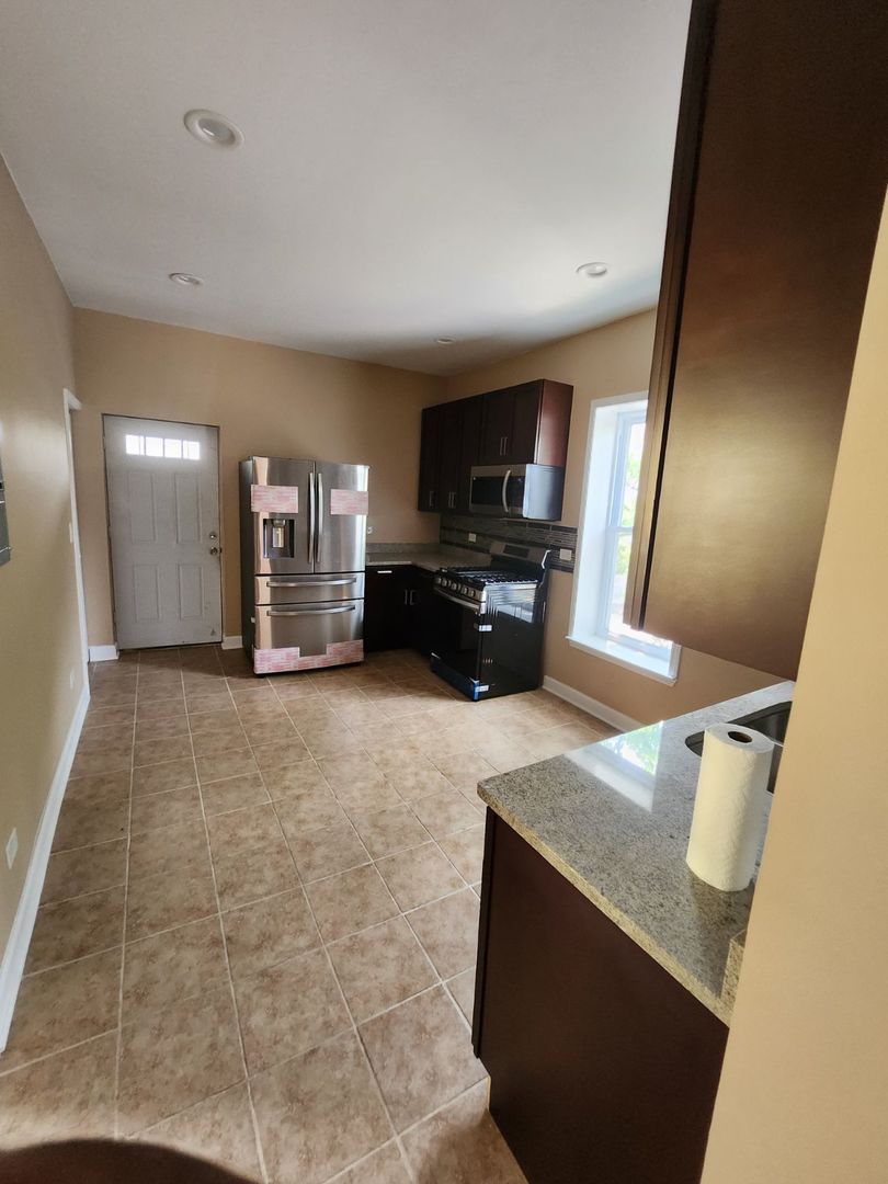 Undisclosed Address Chicago, IL 60624 - Photo 13 of 27 a view of a kitchen with furniture and a flat screen tv