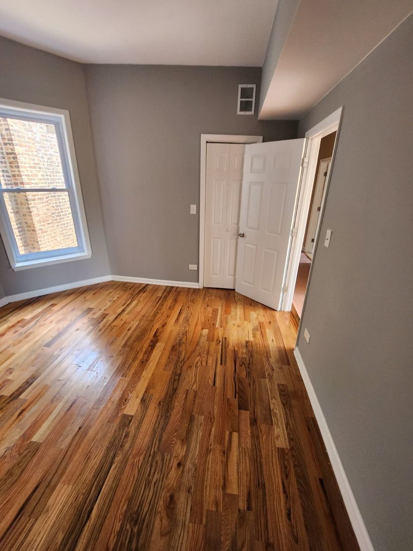 Undisclosed Address Chicago, IL 60624 - Photo 16 of 27 a view of an empty room with wooden floor and a window