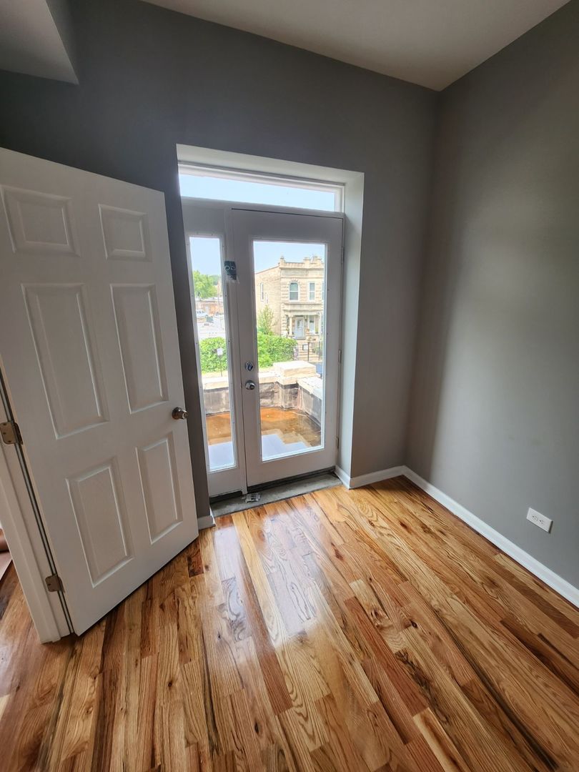 Undisclosed Address Chicago, IL 60624 - Photo 22 of 27 a view of an empty room with wooden floor and a window
