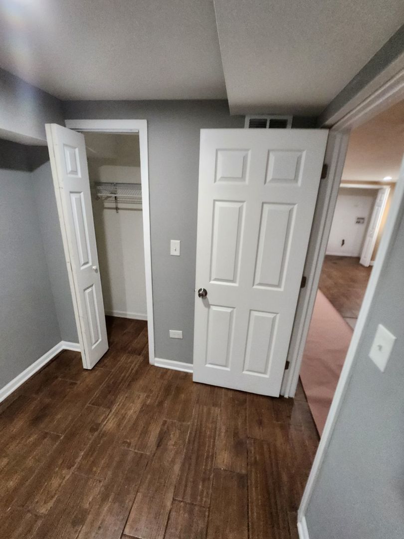 Undisclosed Address Chicago, IL 60624 - Photo 27 of 27 an empty room with wooden floor and stairs