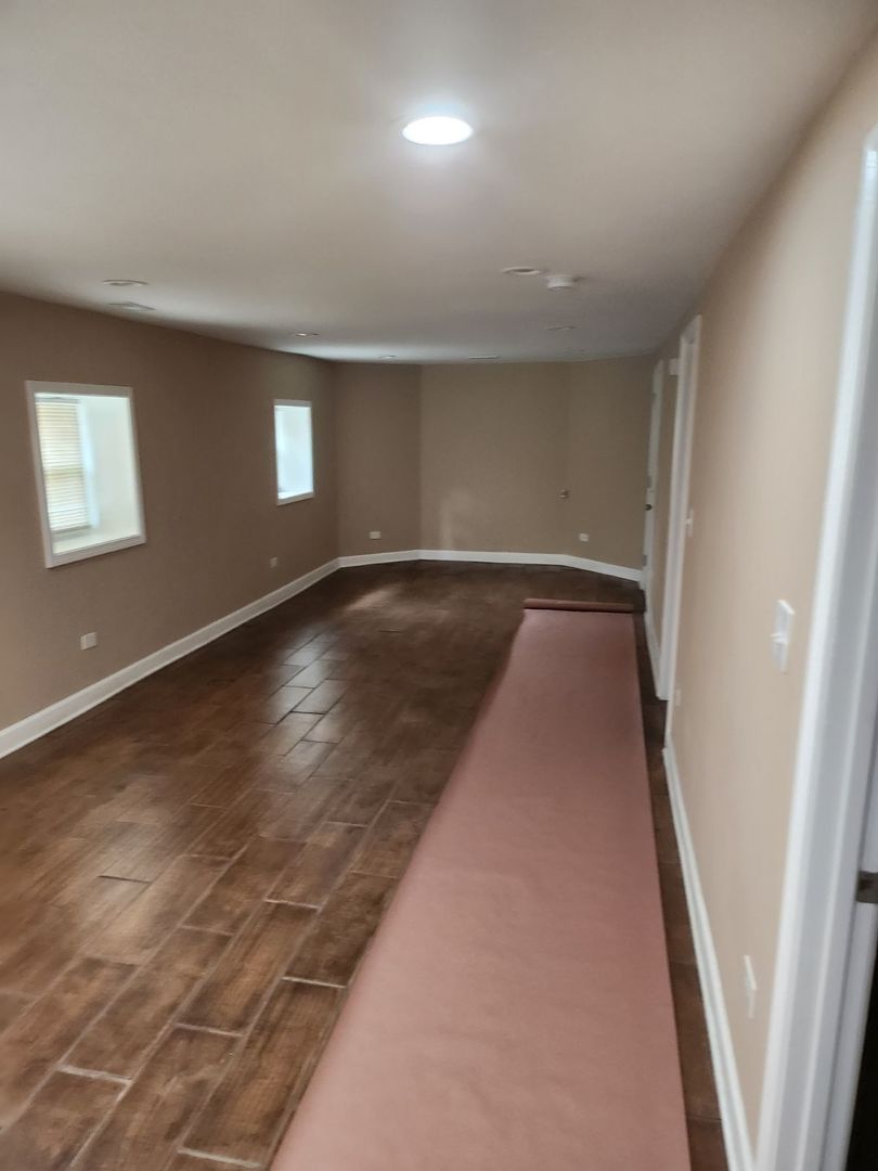 Undisclosed Address Chicago, IL 60624 - Photo 9 of 27 an empty room with wooden floor and windows