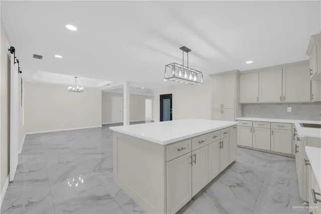 a kitchen that has a lot of cabinets in it and wooden floors