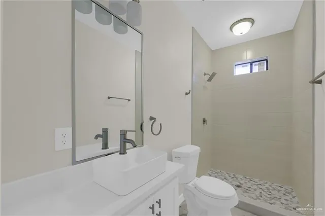 a white toilet sitting next to a bathroom sink and vanity