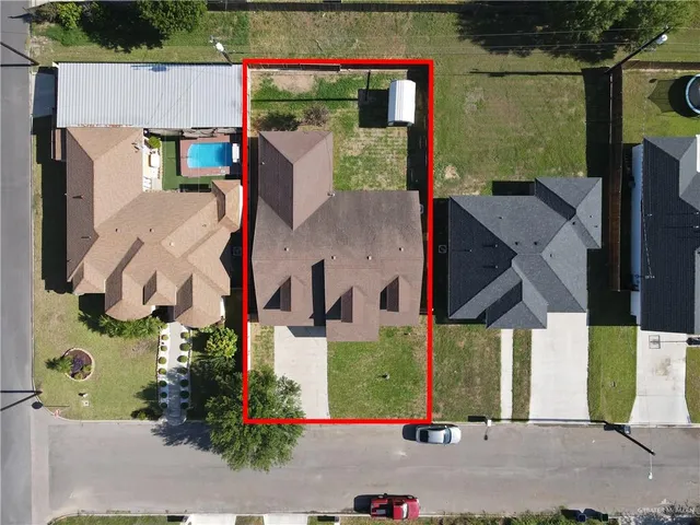 an aerial view of a house with a yard and potted plants