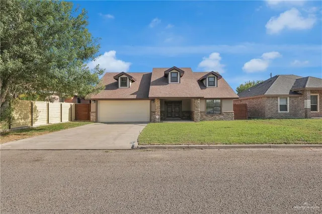 a front view of house with yard and garage