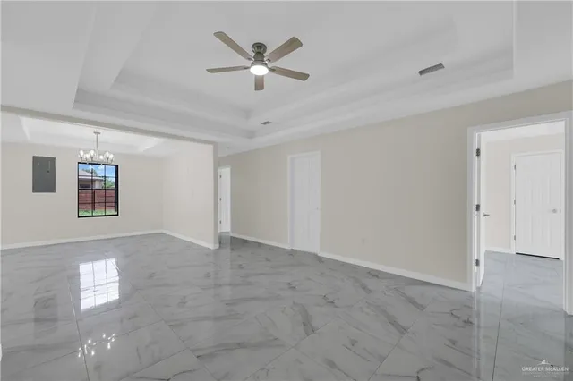 a view of a big room with windows and chandelier fan