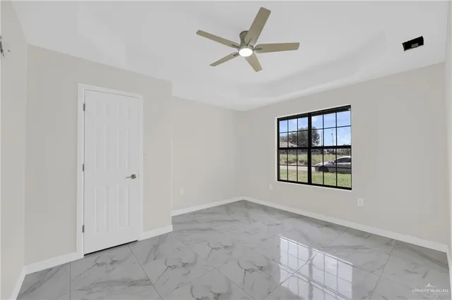 a view of a livingroom with a ceiling fan & windows