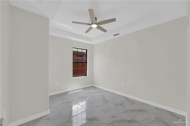 an empty room with a ceiling fan and window