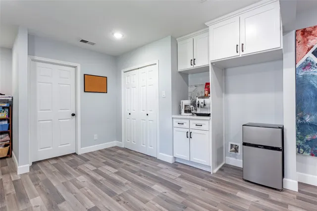 a kitchen with white cabinets and stainless steel appliances