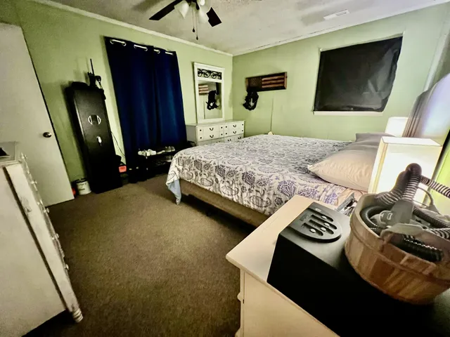 a room with a bed and a flat tv screen on the dresser