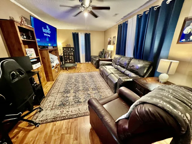 a living room with furniture a flat screen tv and a large window