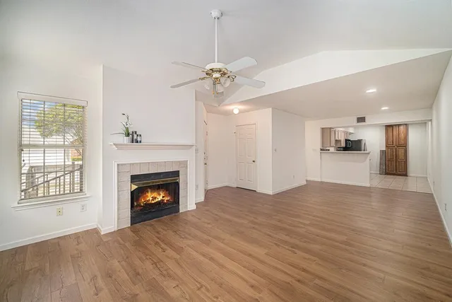 a view of an empty room with a fireplace and a window