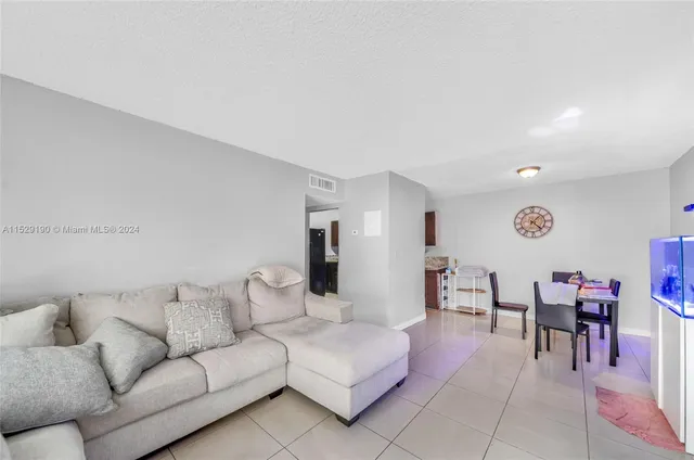a living room with furniture a table and a piano