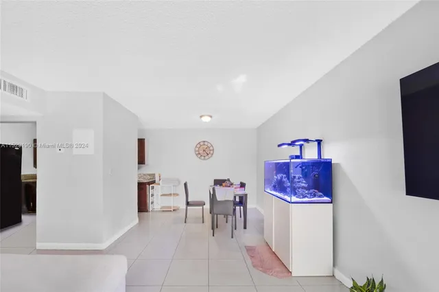 a living room with furniture a dining table and a refrigerator