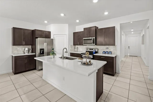 a kitchen with stainless steel appliances a refrigerator sink and microwave