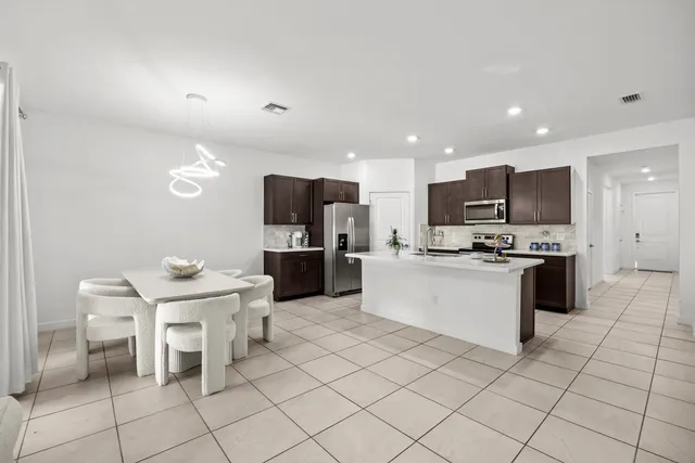 a kitchen with a sink and chairs
