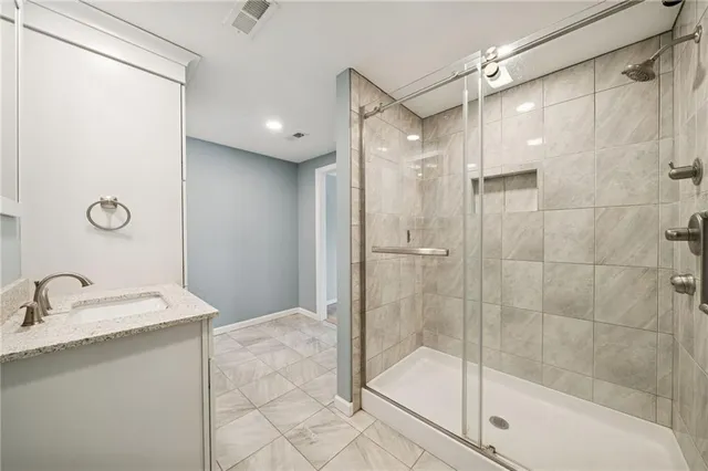 a bathroom with a shower sink and mirror