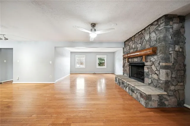 an empty room with windows and fireplace