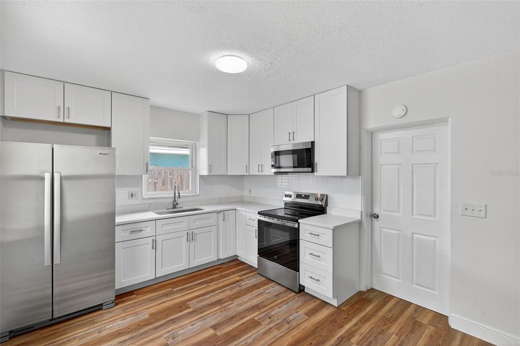 12432 136th Lane Largo, FL 33774 - Photo 16 of 64 a kitchen with stainless steel appliances granite countertop a stove a sink and a refrigerator