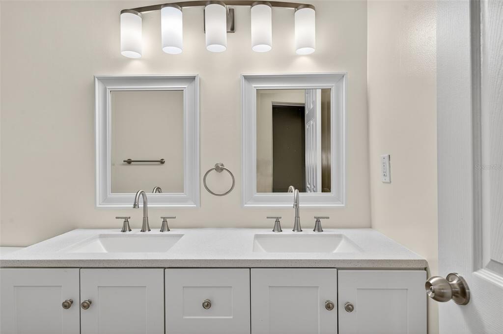 12432 136th Lane Largo, FL 33774 - Photo 30 of 64 a bathroom with a double vanity sink and a mirror