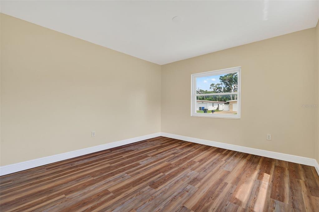 12432 136th Lane Largo, FL 33774 - Photo 38 of 64 an empty room with wooden floor and windows