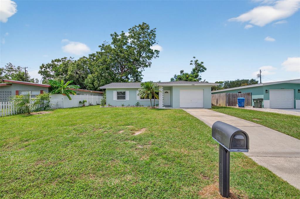 12432 136th Lane Largo, FL 33774 - Photo 6 of 64 a front view of house with yard and trees in the background
