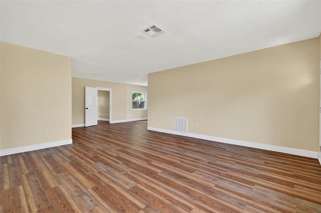 12432 136th Lane Largo, FL 33774 - Photo 9 of 64 a view of an empty room with wooden floor and a window