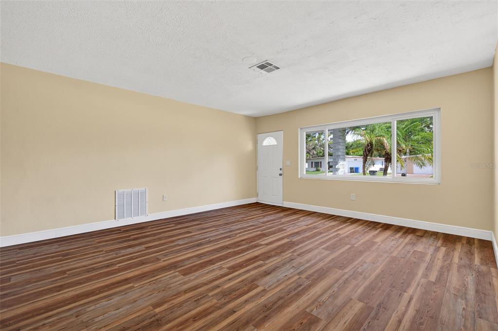 12432 136th Lane Largo, FL 33774 - Photo 10 of 64 a view of an empty room with wooden floor and a window