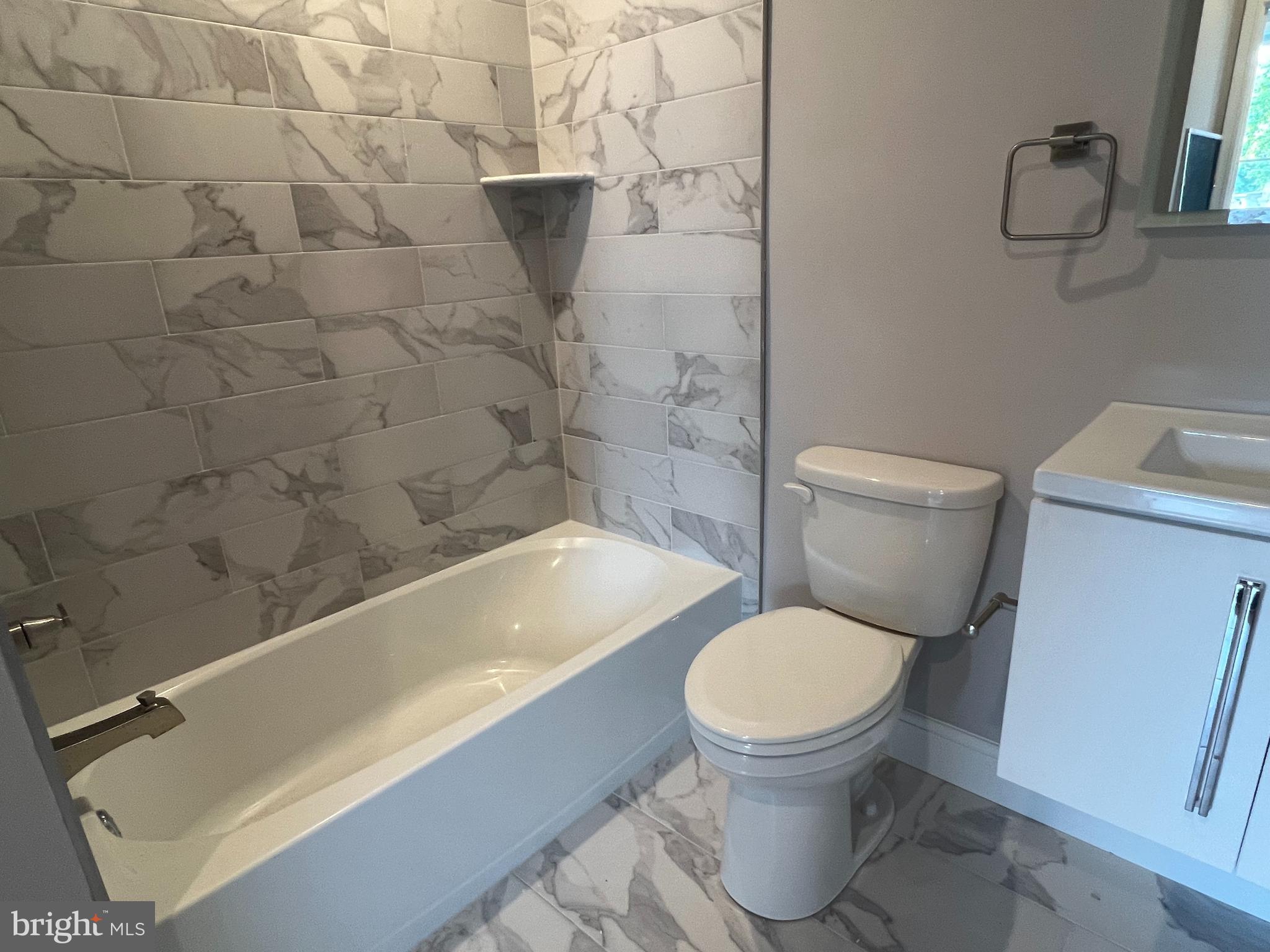 5239 Chancellor Street, Unit B Philadelphia, PA 19139 - Photo 11 of 18 a white toilet sitting next to a bath tub