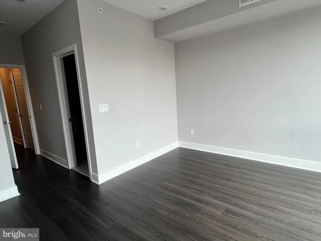 an empty room with wooden floor and entrance