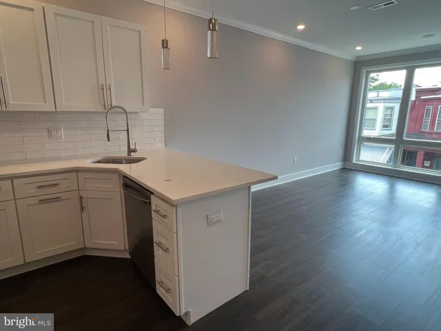 a kitchen with a sink cabinets and wooden floor