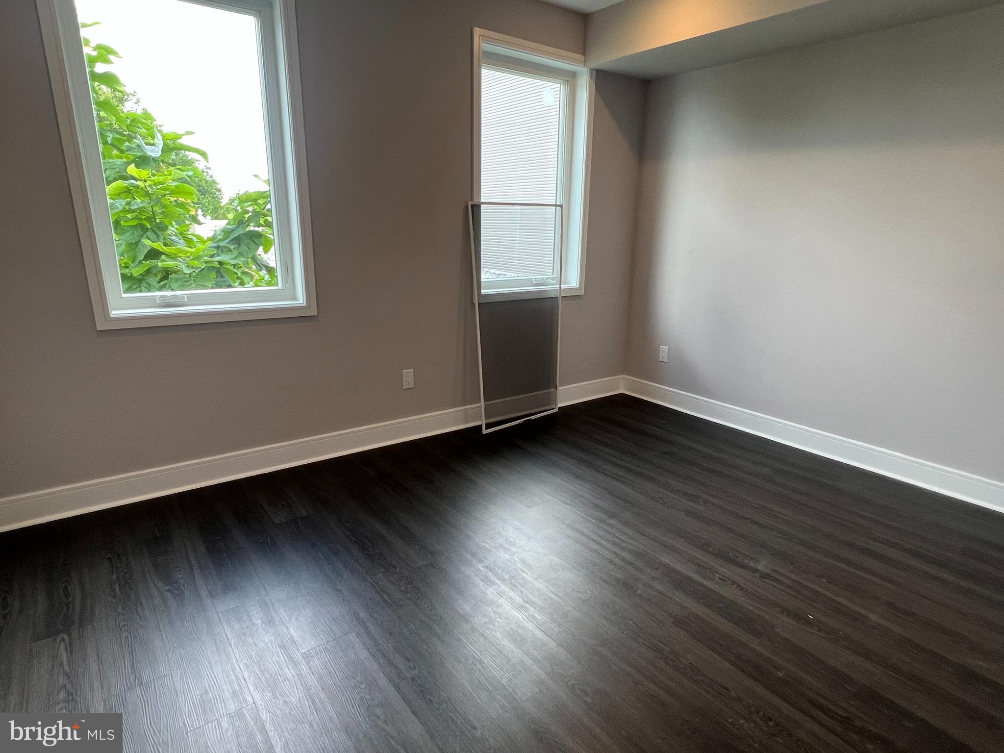 5239 Chancellor Street, Unit B Philadelphia, PA 19139 - Photo 10 of 18 an empty room with wooden floor and windows