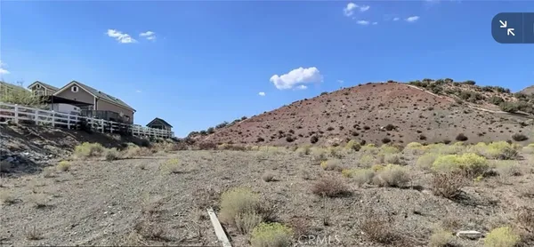 a view of a dry space with mountain in the background