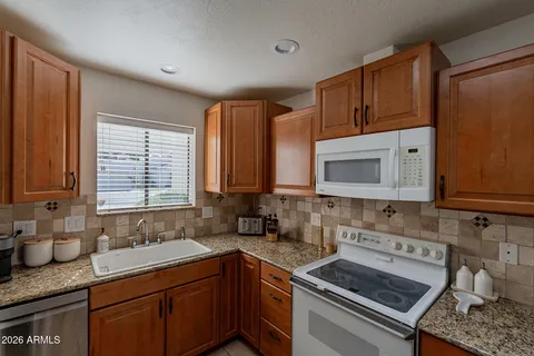 a kitchen with stainless steel appliances granite countertop a sink stove and cabinets