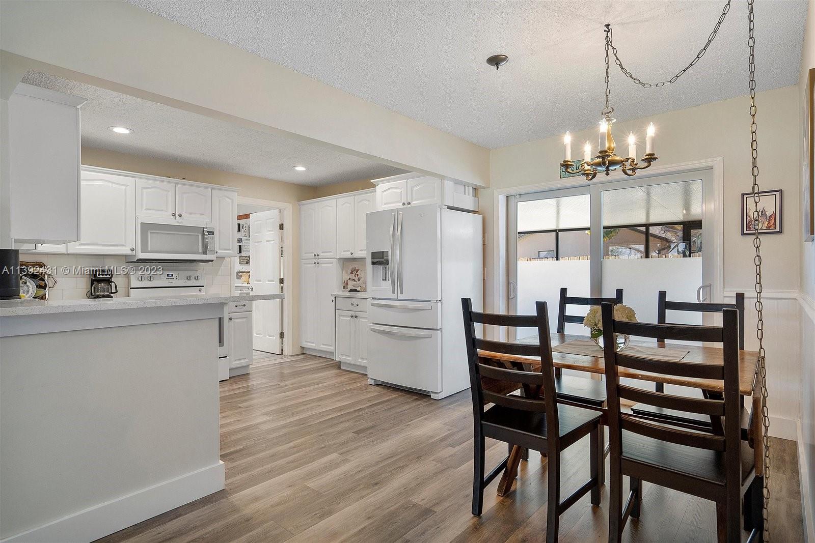 19404 Colorado Circle Boca Raton, FL 33434 - Photo 13 of 62 a kitchen with a table chairs refrigerator and cabinets