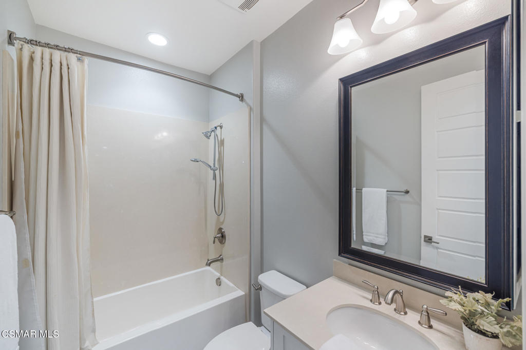13148 Bent Grass Place Moorpark, CA 93021 - Photo 29 of 76 a bathroom with a granite countertop sink mirror and a bathtub